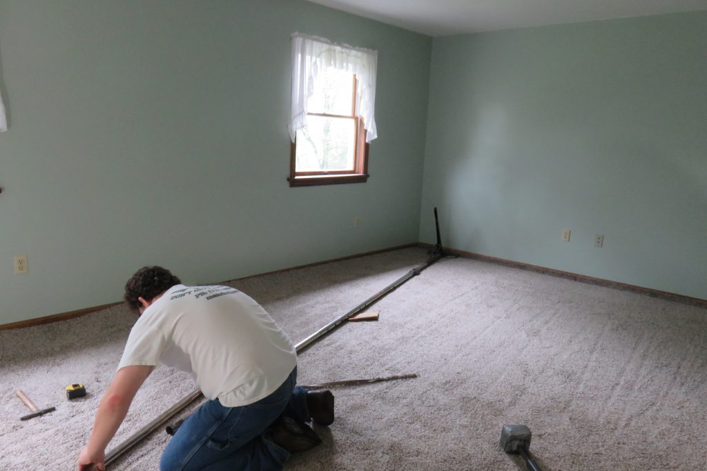 Stretching the Carpet to keep it tight during use.